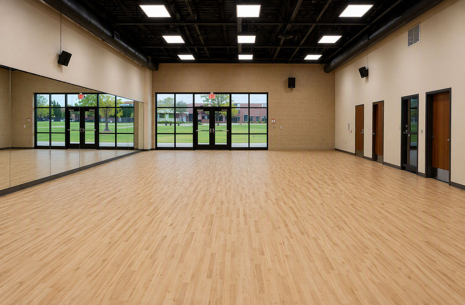 Spacious dance studio featuring a Robbins L-Evate™ Heritage sprung dance floor with mirrored wall and natural maple performance surface